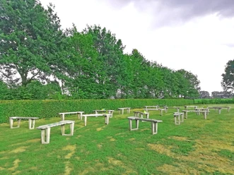Pit-Pat-Anlage Hümmlinger Land Mehrere Pit-Pat-Bahnen auf einer grünen Wiese, umgeben von Bäumen und einer geschnittenen Hecke.