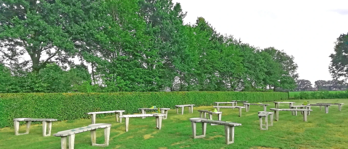 Pit-Pat-Anlage Hümmlinger Land Mehrere Pit-Pat-Bahnen auf einer grünen Wiese, umgeben von Bäumen und einer geschnittenen Hecke.