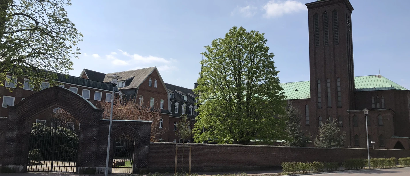 Kloster Thuine 2018.JPG Backsteinbau des Klosters Thuine mit hohem Turm, grünem Kupferdach und umgebenden Bäumen.