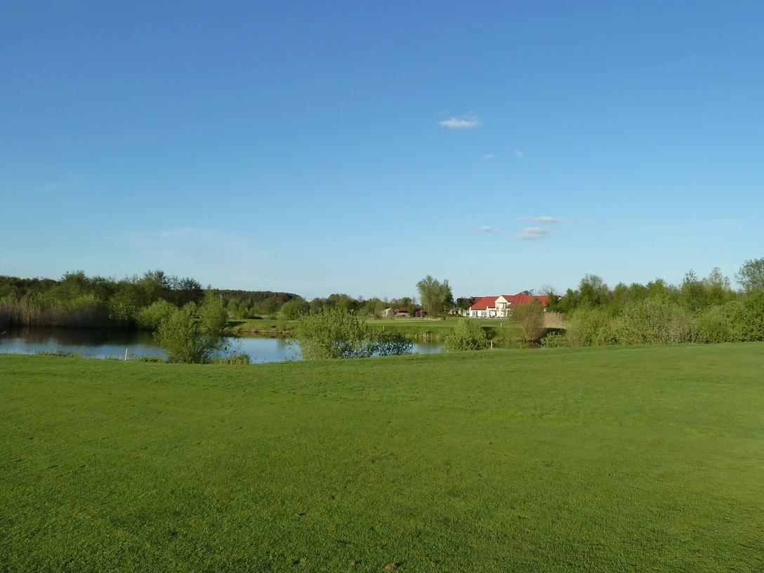 Golfplatz Achim Grüne Landschaft mit Golfplatz im Vordergrund, einem kleinen See und einem roten Gebäude im Hintergrund.Green landscape with a golf course in the foreground, a small lake and a red building in the background.Grønt landskab med en golfbane i forgrunden, en lille sø og en rød bygning i baggrunden.Groen landschap met een golfbaan op de voorgrond, een meertje en een rood gebouw op de achtergrond.