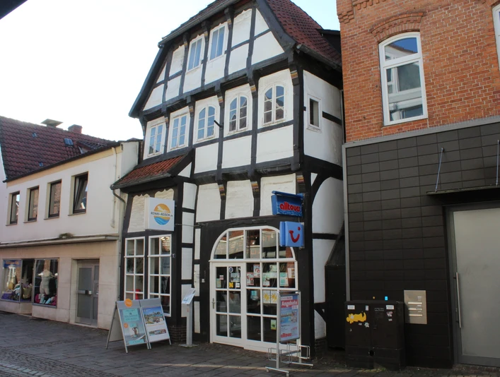 Fachwerkhaus mit Schaufenstern, Läden im Erdgeschoss und markanten Holzdetails an der Fassade.