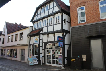 Ackerbürgerhaus Fachwerkhaus mit Schaufenstern, Läden im Erdgeschoss und markanten Holzdetails an der Fassade.