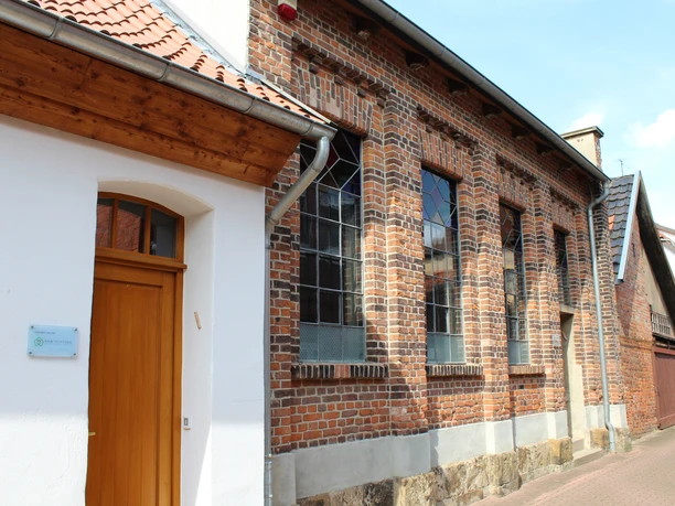 Alte Synagoge Backsteinfassade der Alten Synagoge mit charakteristischen Fensterbögen unter blauem Himmel.