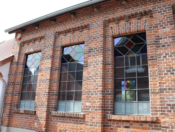 Alte Synagoge Rote Backstein-Synagoge mit hohen, bunten Bleiglasfenstern, historisch und kulturell bedeutend.