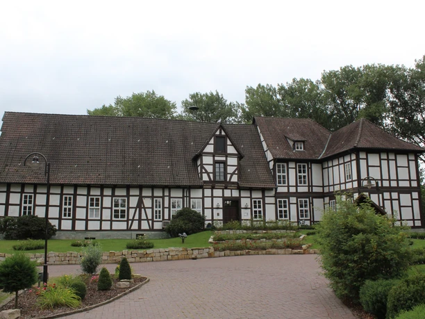 Amtshof Steyerberg Fachwerkgebäude des Amtshofs Steyerberg mit gepflasterter Einfahrt und umgebenden Bäumen im Hintergrund.