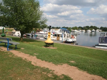Marina Mehlbergen Marina Mehlbergen: Boote und Yachten entlang eines grünen Ufers, umgeben von ruhiger Wasserfläche.