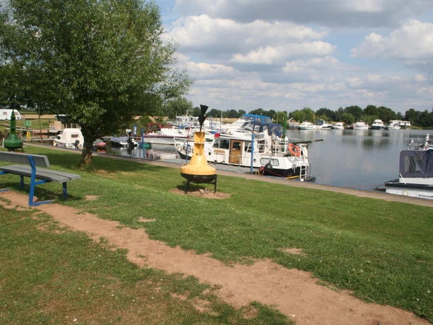 Marina Mehlbergen Marina Mehlbergen: Boote und Yachten entlang eines grünen Ufers, umgeben von ruhiger Wasserfläche.