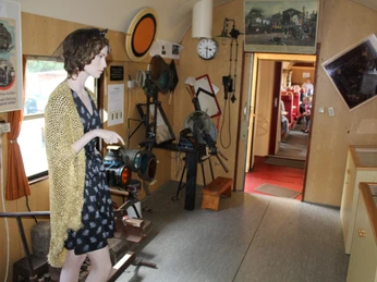 Museumslok Ausstellung Eine Frau betrachtet eine Ausstellung historischer Eisenbahnutensilien in einem Museumswagen.A woman looks at an exhibition of historical railroad utensils in a museum car.En kvinde ser på en udstilling af historisk jernbaneudstyr i en museumsvogn.Een vrouw bekijkt een tentoonstelling van historische spoorwegattributen in een museumwagon.
