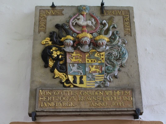 Kirche Lavelsloh Ein aufwendig gestaltetes Wappen mit lateinischer Inschrift und Inschrift über Herzog Wilhelm.