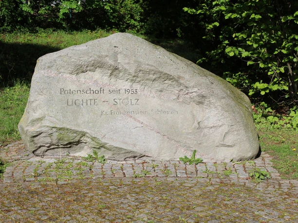 Ein großer Gedenkstein in einer sonnigen Umgebung, gewidmet der Patenschaft von Lichte-Stolz.