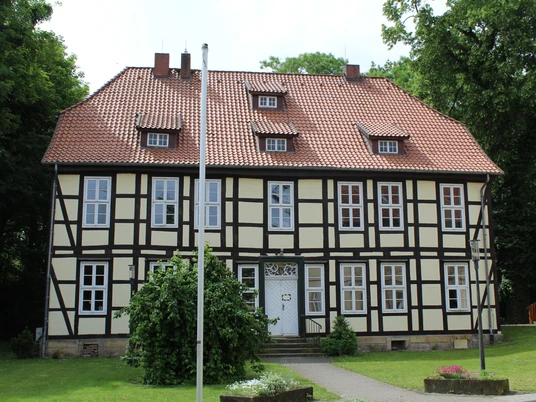 Amtshof Stolzenau Ein zweigeschossiges Fachwerkgebäude mit roten Dachziegeln und mehreren symmetrisch angeordneten Fenstern.