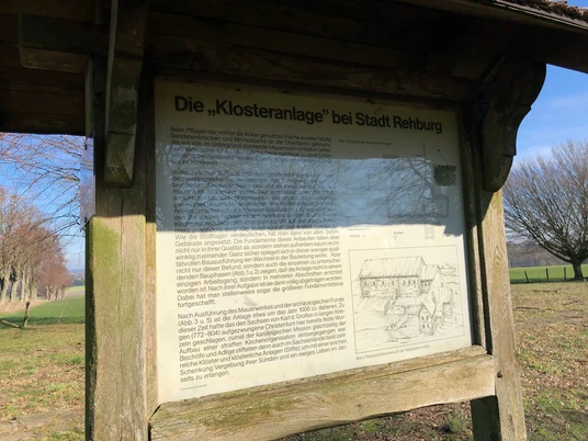 Kloster Asbeke Schild an der ehemaligen Klosteranlage; Informationstext und Zeichnung vor Landschaftskulisse.Sign at the former monastery complex; information text and drawing in front of a landscape backdrop.Skilt ved det tidligere klosterkompleks; informationstekst og tegning foran en landskabsbaggrund.Bord bij het voormalige kloostercomplex; informatietekst en tekening voor een landschappelijke achtergrond.