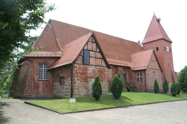 Ev.-luth. Johannis der Täufer-Kirche in Drakenburg Backsteinkirche aus der Gotik in Drakenburg mit markantem Schnittgiebel und vereinzelt stehenden Bäumen.