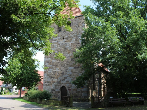 Kirche Buchholz Historische Steinmauern der Kirche Buchholz, umgeben von Bäumen, einladend zum Entdecken.