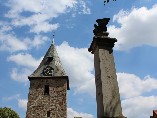 Kirche Schlüsselburg Historische Kirche mit einem steinernen Turm und nicht weit entfernt befindet sich ein Denkmal.