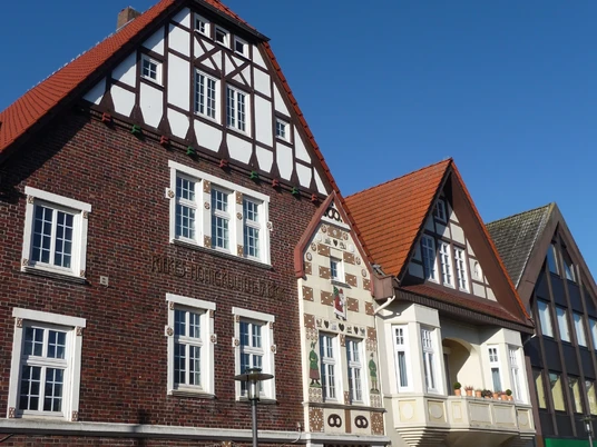 Fachwerkhaus mit verzierten Klinkerfassaden und Holzdetails vor blauem Himmel in Niedersachsen.