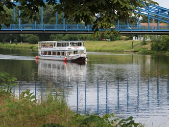 Die FGS Bremen in Nienburg Das Fahrgastschiff Bremen passiert die Weserbrücke bei Nienburg auf einem grünen, ruhigen Fluss.