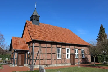Historische Fachwerkkapelle mit rotem Ziegeldach und Kirchturm vor klarem blauen Himmel in Winzlar.