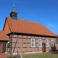 Historische Fachwerkkapelle mit rotem Ziegeldach und Kirchturm vor klarem blauen Himmel in Winzlar.