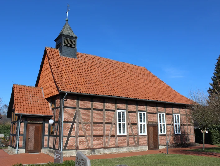 Historische Fachwerkkapelle mit rotem Ziegeldach und Kirchturm vor klarem blauen Himmel in Winzlar.