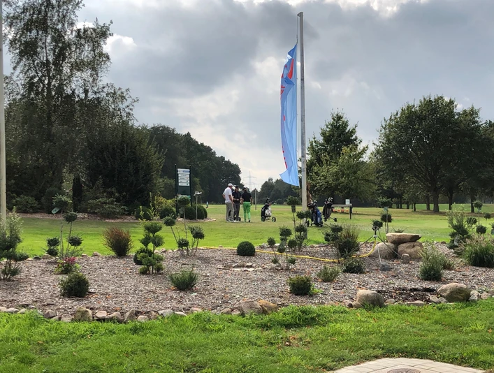 Golfplatz Rehburg-Loccum Golfer bereiten sich auf einer gepflegten Grünfläche mit umliegenden Bäumen unter blauem Himmel vor.Golfers prepare on a well-kept green with surrounding trees under a blue sky.Golfspillere forbereder sig på en velplejet green med omgivende træer under en blå himmel.Golfers bereiden zich voor op een goed onderhouden green met omringende bomen onder een blauwe hemel.