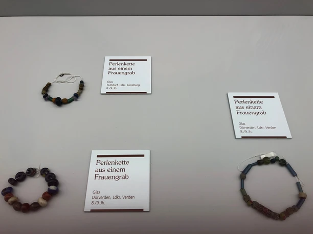 Glass bead necklaces from the 8th/9th century, on display at the Landesmuseum Hannover, arranged in a circle.