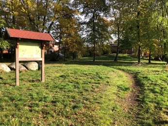 Grabhügelfeld in Nienburg Wegweiser führt zu einem Grabhügelfeld in Nienburg, umgeben von herbstlich gefärbten Bäumen.