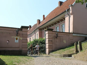Ehemaliges Grafenschloss Hoya Altes Grafenschloss mit rötlichen Mauern und Fenstern, vor grüner Hecke und gepflastertem Weg.Old count's castle with reddish walls and windows, in front of a green hedge and cobbled path.Gammel greveborg med rødlige mure og vinduer foran en grøn hæk og en brostensbelagt sti.Oud kasteel van de graaf met roodachtige muren en ramen, voor een groene haag en een geplaveid pad.
