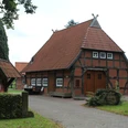 Heimathaus Wechold Historisches Fachwerkhaus mit Ziegeldach und Brunnendekor, umgeben von Bäumen in ruhiger Lage.