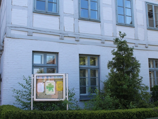 Heimatmuseum Grafschaft Hoya: Historisches Fachwerkgebäude mit Schautafel und begrüntem Umfeld.
