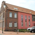 Heimatmuseum Stolzenau Backsteinfassade des Heimatmuseums Stolzenau mit modernen Anbauten und geparkten Autos davor.