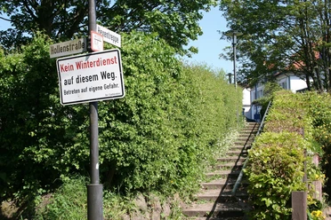 Hexentreppe Eine grüne Treppe führt mit einem Schild "Kein Winterdienst" durch üppiges Laub ins Unbekannte.