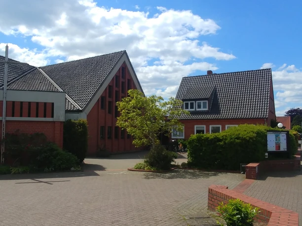 Die katholische Kirchengemeinde Heilige Familie zeigt moderne Architektur mit roten Ziegelmauern.