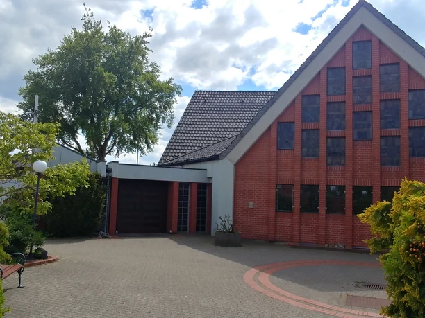 Kath. Kirchengemeinde Heilige Familie Weyhe Backsteinfassade der katholischen Kirche mit hohen Fenstern und eingefriedetem Vorplatz in Weyhe.