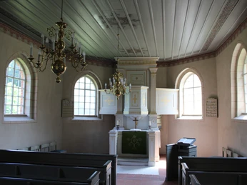 Kunstvoller Barockaltar in einer lichten Kirche mit hohen Fenstern und feinen Deckenornamenten.