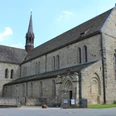 Kloster Loccum Romanische Fassade des Klosters Loccum mit hohen Fenstern und einem spitzen Turm bei klarem Himmel.