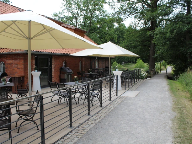 Klostermühle Heiligenberg Op deze foto zie je een terras van de kloostermolen Heiligenberg met zitjes en parasols.