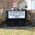 Kohlelore in Münchehagen Eine alte Kohlelore beladen mit Kohlen vor einer Hecke und Schildern des Bergmannsvereins Münchehagen.