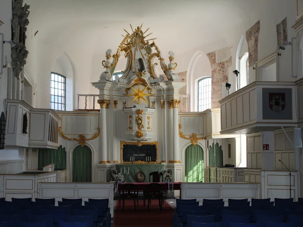 Kulturzentrum Martinskirche Innenraum Historische Innenansicht der Martinskirche mit kunstvoll verzierten weißen und goldenen Elementen.