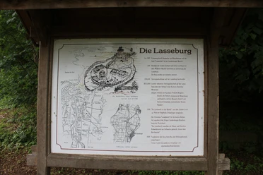 Landesbergen Lasseburg Schild mit Lageplan und Historie der Lasseburg in Landesbergen, umgeben von üppigem Grün.