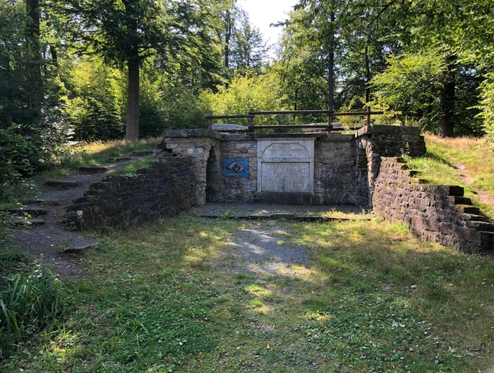 Luccaburg Ruinen einer historischen Steinmauer inmitten eines lichten Waldes an einem sonnigen Tag.