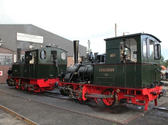 Alte Dampflokomotive Franzburg steht vor einem Gebäude mit der Aufschrift "Betriebswerkstatt".Old steam locomotive Franzburg stands in front of a building labeled "Betriebswerkstatt".Det gamle damplokomotiv Franzburg står foran en bygning med betegnelsen "Betriebswerkstatt".Oude stoomlocomotief Franzburg staat voor een gebouw met het opschrift "Betriebswerkstatt".