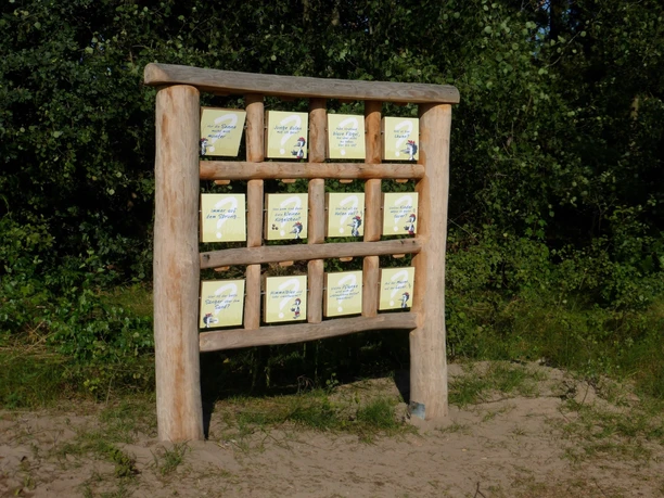 Naturerlebnispfad Achimer Stadtwald Holzgerüst mit neun Schautafeln im Grünen, präsentiert verschiedene Informationen über den Stadtwald.