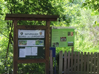 BUND Naturnaher Schau- und Lehrgarten Informationstafeln des BUND Naturnaher Schau- und Lehrgarten, umgeben von üppigem Pflanzenwuchs.