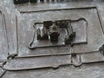 Stadtmodell Ein bronzenes Stadtmodell zeigt die historische Innenstadt mit zentralem Gebäude und umgebender Struktur.