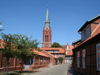 Kirchturm von St. Martin in Nienburg überragt umgebende Backsteingebäude, blauer Himmel im Hintergrund.Church tower of St. Martin in Nienburg towers above surrounding brick buildings, blue sky in the background.Martin's i Nienburg tårner sig op over de omkringliggende murstensbygninger med blå himmel i baggrunden.De kerktoren van St Martin in Nienburg torent boven de omringende bakstenen gebouwen uit, blauwe lucht op de achtergrond.