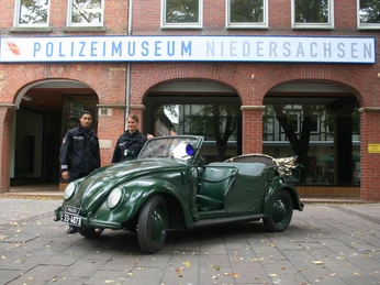 Niedersächsisches Polizeimuseum Zwei Polizeibeamte stehen neben einem grünen VW-Käfer-Cabriolet vor dem Polizeimuseum Niedersachsen.Two police officers stand next to a green VW Beetle convertible in front of the Lower Saxony Police Museum.To politibetjente står ved siden af en grøn VW Beetle cabriolet foran Niedersachsens politimuseum.Twee politieagenten staan naast een groene VW Kever cabriolet voor het politiemuseum van Nedersaksen.