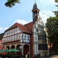 Rathaus Nienburg Historisches Rathaus Nienburg mit markantem Glockenturm, Fachwerkfassade und bunter Außengastronomie.