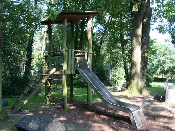 Rathauspark Achim Rathauspark Achim: Spielplatz mit Holzklettergerüst, Rutsche und grüner Umgebung; kinderfreundlich.