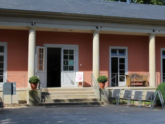 Tourist-Info Romantik Bad Rehburg Tourist information in Bad Rehburg with open entrance door and steps, surrounded by columns.